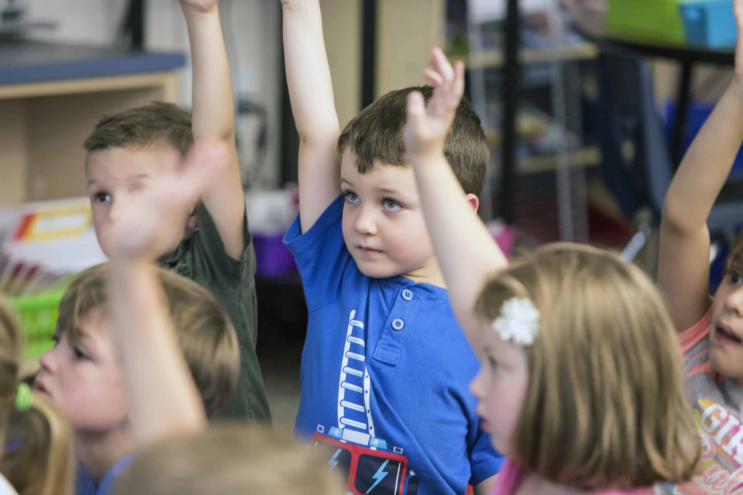 Alpine Elementary student raising his hand