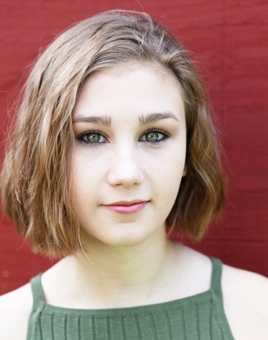 Graduate in a green shirt and red backdrop