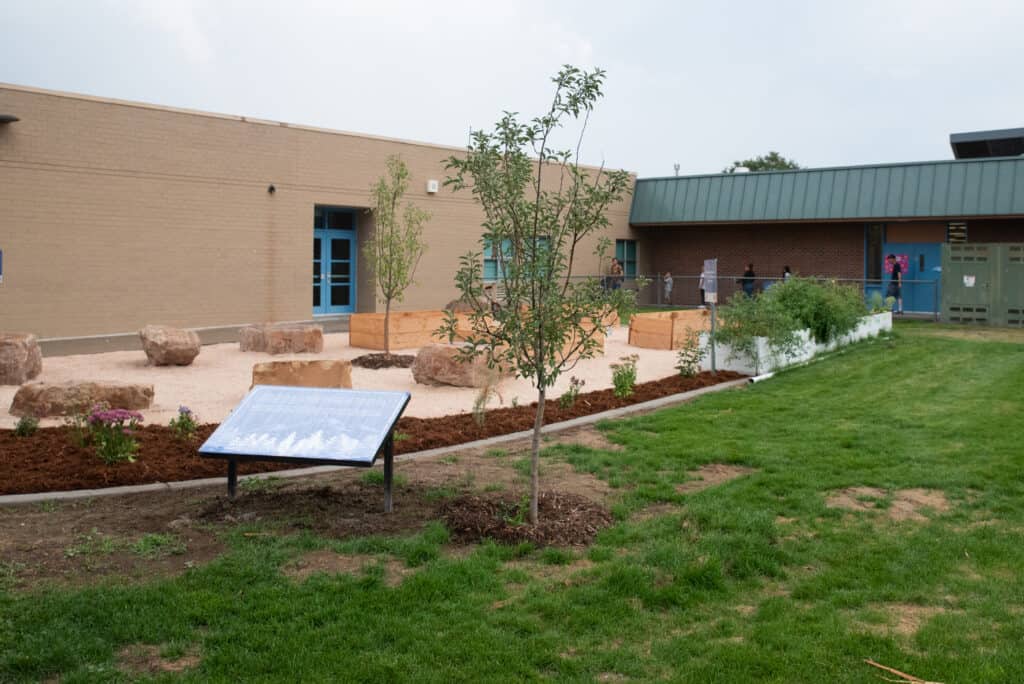 A picture of the outdoor classroom- green grass, red rocks.