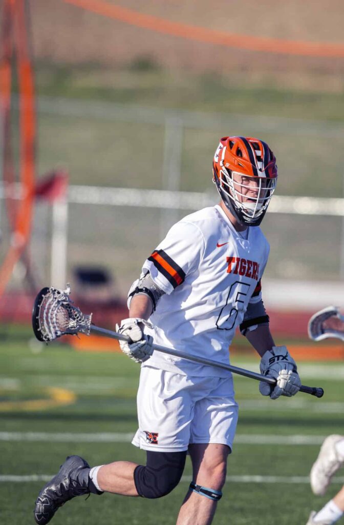 two male high school students playing lacrosse