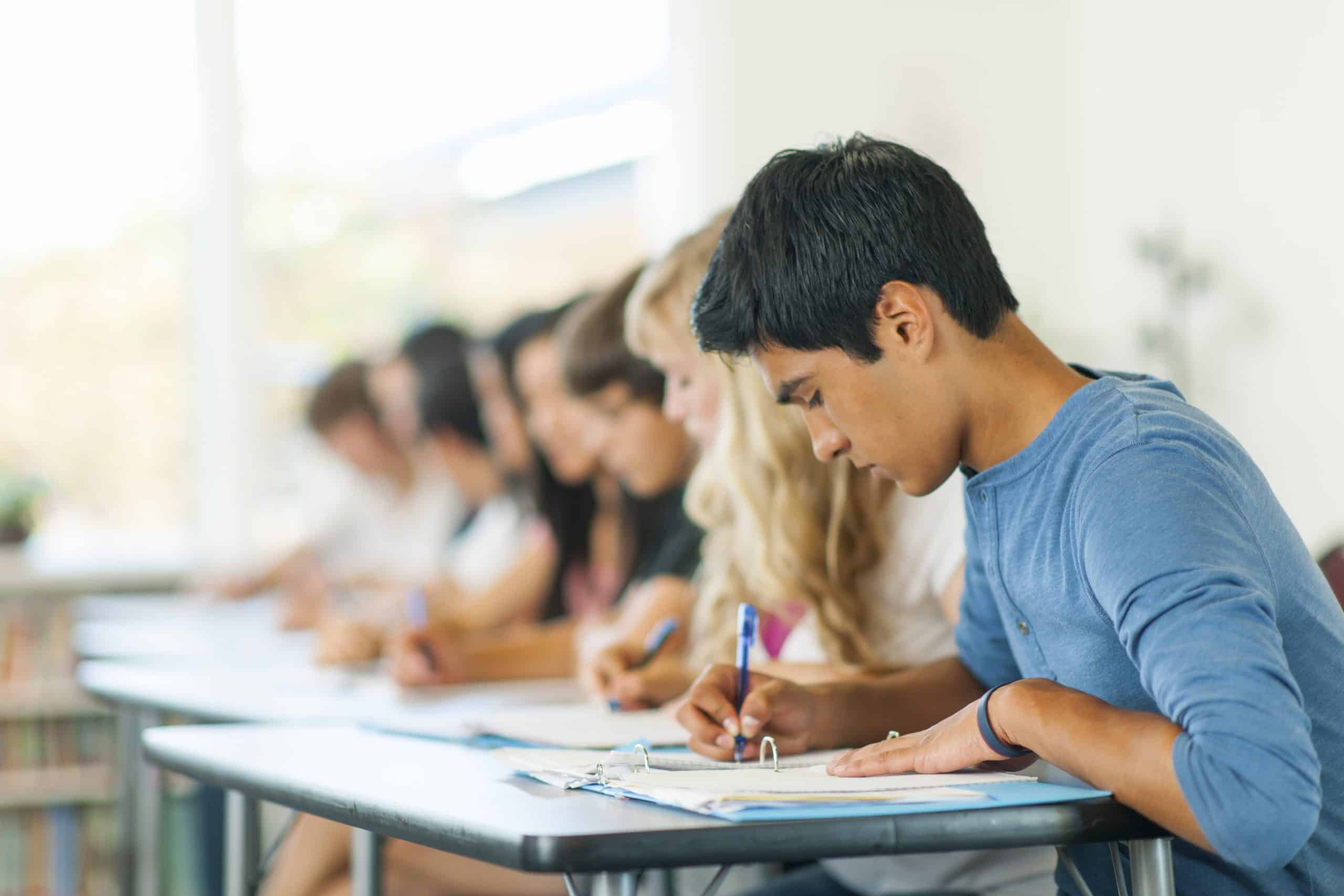 Alumnos en fila realizando un examen