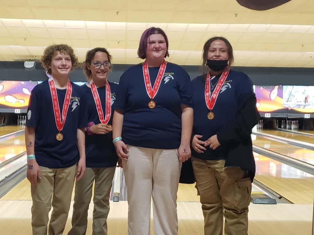 El equipo de Frederick HS posa con las medallas del Campeonato Estatal