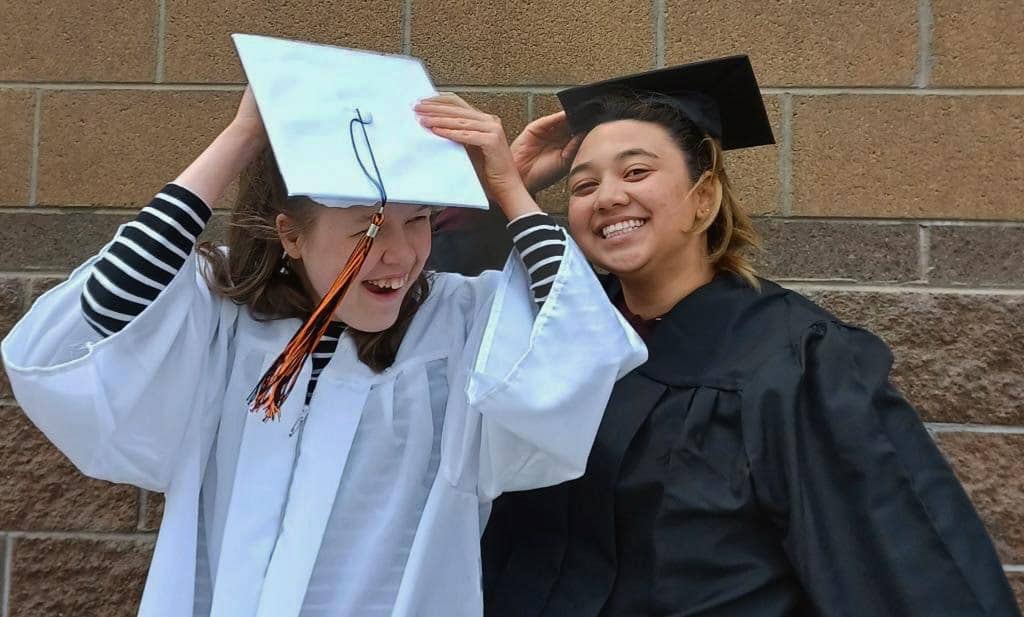 Peer Mentor Trying on Graduation Gowns with Peer