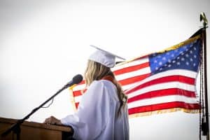 Estudiante en la graduación con la bandera