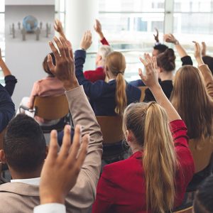 Manos levantadas en una reunión comunitaria