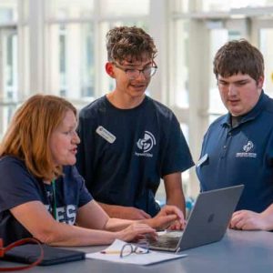 students and teacher at laptop