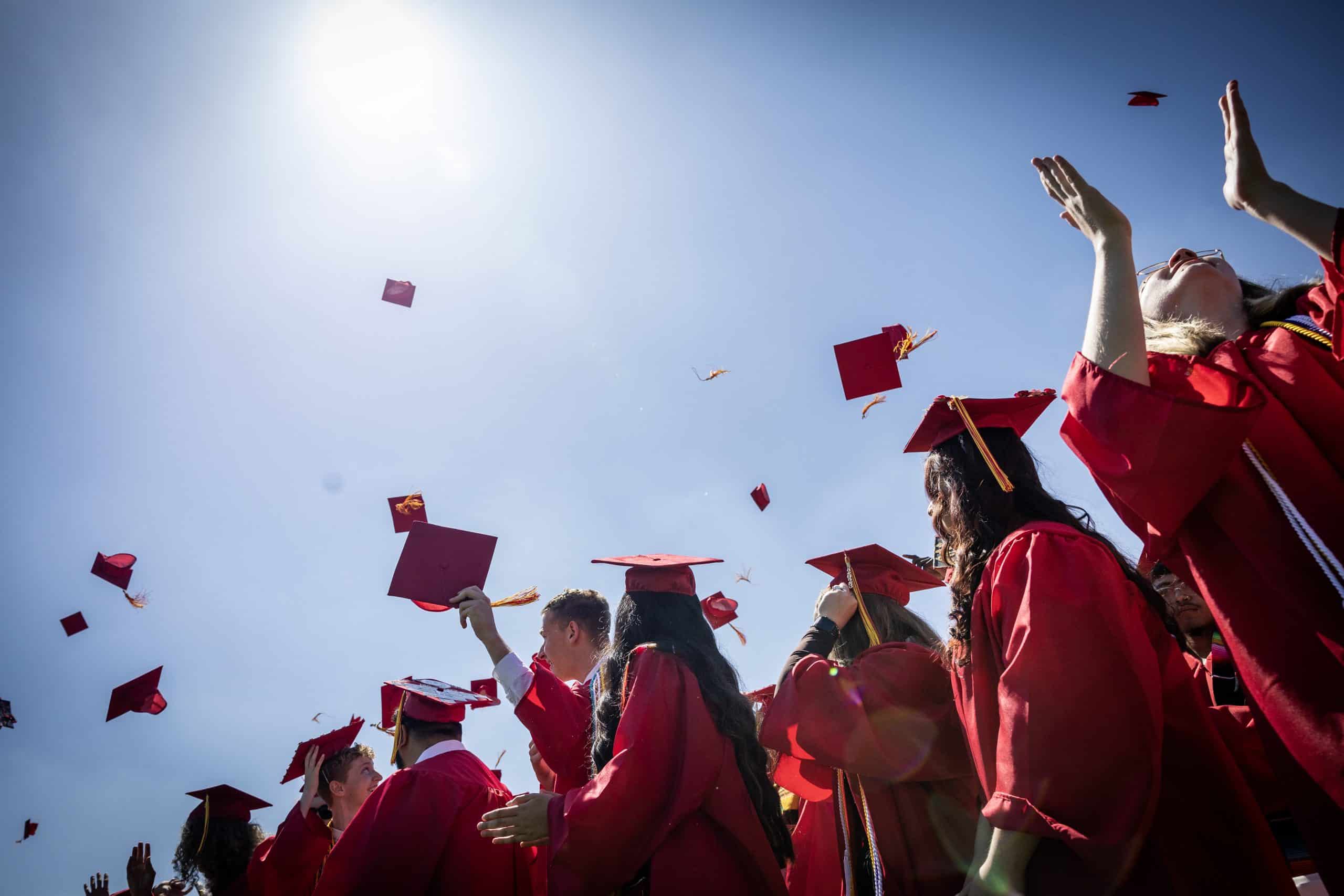 Skyline High Alumnos de la escuela lanzan sus birretes al aire durante la ceremonia de graduación de 2023.