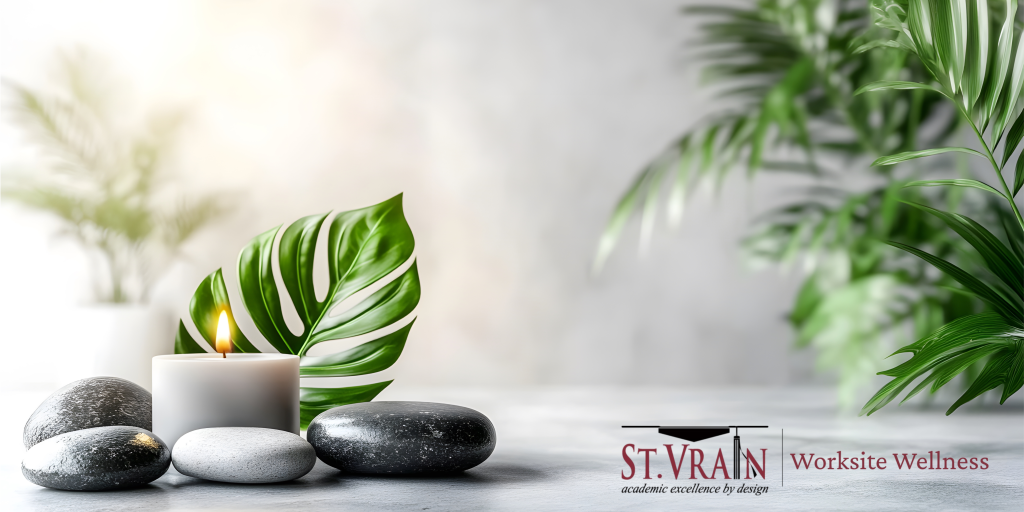 A lit candle surrounded by smooth stones and green leaves, creating a serene and calming atmosphere.