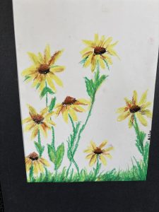 A colorful drawing of yellow flowers with brown centers, surrounded by green leaves and grass on a white background.