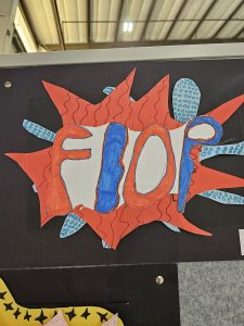 Colorful sign displaying the word "FLOP" in bold letters, surrounded by decorative shapes and patterns.