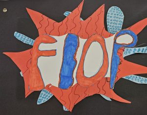 Colorful paper art featuring the word "FLOP" in bold letters, surrounded by red and blue decorative shapes.