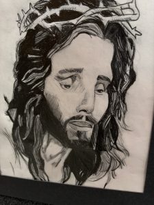 A detailed sketch of a man with long hair and a beard, wearing a crown of thorns, expressing a somber emotion.