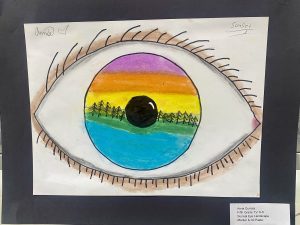 A colorful drawing of an eye with a vibrant sunset landscape inside the iris, featuring trees and a black pupil.