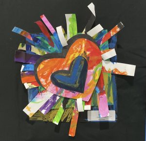 Colorful heart collage with vibrant paper strips radiating outward against a black background.