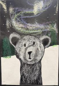 A bear stands in a snowy landscape under a night sky with colorful auroras and green trees in the background.