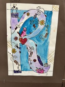 Colorful illustration of the letter "R" with flowers, a pink cat, and craft items on a blue background.