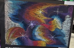 Colorful abstract artwork depicting swirling patterns in shades of purple, blue, orange, and white stars.