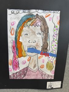 A colorful child’s drawing of a person with a blue object in their mouth, surrounded by various shapes and colors.