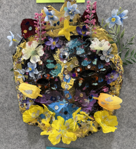 Colorful mask decorated with flowers, glitter, and beads, showcasing vibrant artistic details on a textured background.
