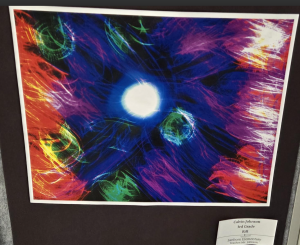 Colorful abstract artwork featuring swirls of blue, red, green, and yellow, with a central white circle.