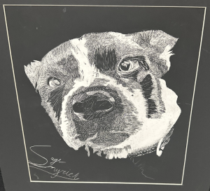 A detailed black-and-white drawing of a dog's face with expressive eyes and distinct markings.