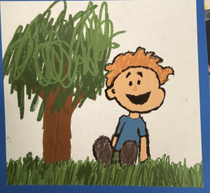 A cheerful child with orange hair sits on grass beside a large green tree, smiling happily.
