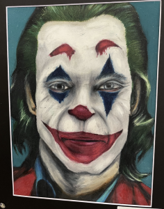 A colorful portrait of a clown with green hair, red and blue face paint, and a bright red smile.