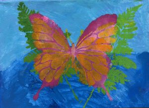 A colorful butterfly with orange and pink wings is surrounded by green ferns, set against a blue background.