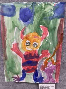 Colorful watercolor drawing of a smiling monster with horns, alongside a smaller pink creature in a green background.