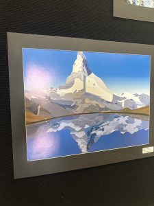 A stylized mountain landscape with a reflection in a calm lake, showcasing vibrant blues and earthy tones.