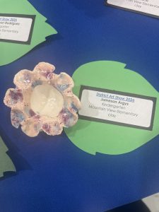 A handmade clay flower dish with a glossy white center, displayed at the District Art Show 2026.