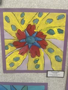 A colorful painting featuring a large red and blue flower on a bright yellow background with green dots.