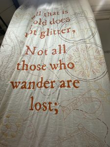 A textured banner featuring a quote in large orange letters about wisdom and exploration, surrounded by intricate designs.