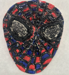 A textured mask resembling Spider-Man, featuring red and blue web patterns with large black eye areas.
