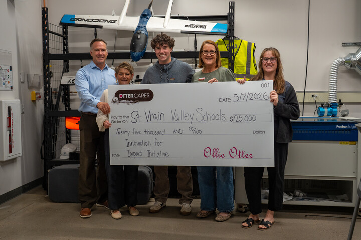 Group of five people holding a large check for $25,000 to St. Vrain Valley Schools for an innovation initiative.